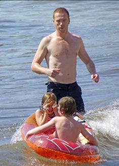 a man and two children riding on an inflatable raft