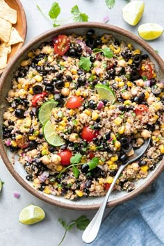 a bowl filled with black beans, corn and cilantro next to tortilla chips