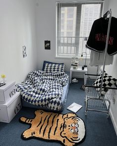 a bedroom with a bed, dresser and rug in it's corner area next to a window