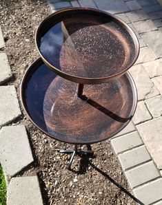 three tiered trays sitting on top of each other in front of a brick walkway