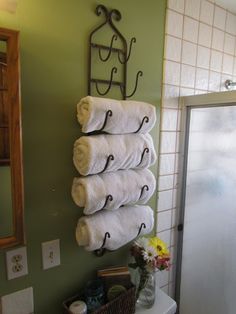 towels are hanging on the towel rack in this bathroom with green walls and white tile flooring