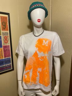 Canyon club White top with orange male graphic| size medium🧡🧡 (it's in new condition, just wrinkled lol) This item will ship within 1-3 days 💌Feel free to message and ask about sizing 📐 Casual Orange Tops With Graphic Design, Orange Graphic Print Tops For Streetwear, Orange Graphic Tee With Graphic Design, Casual Orange Fan Merchandise Top, Casual Orange T-shirt For College, Retro Orange T-shirt For Streetwear, Orange Retro Streetwear T-shirt, Orange Graphic Print Tops For Fan Merchandise, Orange Cotton Top With Graphic Design