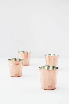 four small cups sitting on top of a white table