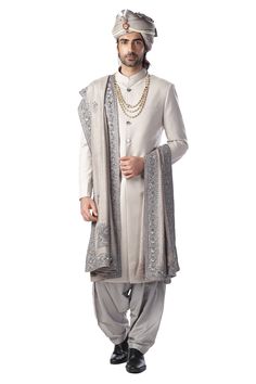 Light grey sherwani with band collar, mother of pearl buttons and full sleeves. Comes with silver patiala, embroidered stole and turban.
Component: 3
Embroidered
Neckline: Band Collar
Sleeve Length: Full
Fabric: Cotton Silk, Silk
Color: Grey, Silver
Patch pocket
Embroidered stole
Turban with attached pearl strings and brooch
Note: The necklace worn by the model is not for sale - Aza Fashions Traditional Silver Kurta With Traditional Drape, Silver Traditional Wear With Intricate Embroidery For Eid, Traditional Silver Kurta With Dupatta, Traditional Silver Kurta With Resham Embroidery, Bollywood Style Silver Kurta For Wedding, Silver Embroidered Sets With Traditional Drape, Elegant Silver Kurta For Eid, Traditional Silver Sherwani For Festive Occasions, Silver Sherwani For Eid Wedding