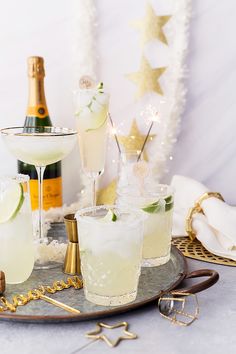 a tray topped with glasses filled with different types of drinks and garnishes