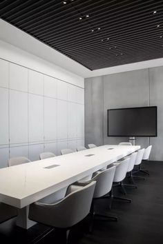 an empty conference room with chairs and a flat screen tv mounted on the wall above it