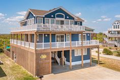 a blue house with white balconies on the top floor and second story balcony