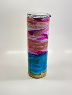 a colorful glass vase sitting on top of a white table