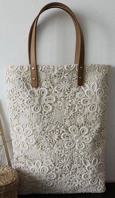 a white bag sitting on top of a wooden table next to a vase and wicker basket