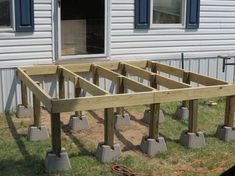 an unfinished wooden deck in front of a house