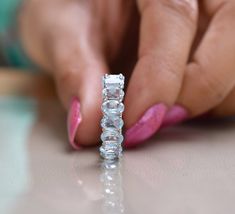 a woman's hand touching the side of a diamond ring