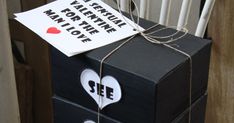 a black box with two white hearts on it and a sign attached to the top