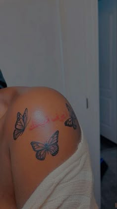 a woman with butterfly tattoos on her shoulder and chest is looking at the camera while she's taking a selfie