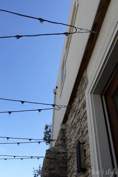 there are many lights strung from the side of this building in front of a window