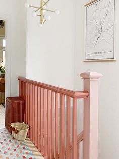 a hallway with pink railing and rug on the floor