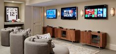 a living room filled with furniture and flat screen tvs on the wall above them