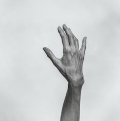 a person's hand reaching up into the air