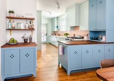 a kitchen with blue cabinets and wooden floors