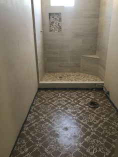 a walk in shower sitting inside of a bathroom next to a tiled floor and walls