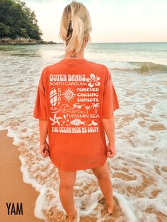 Dive into coastal vibes with our Outer Banks retro style t-shirt. Perfect for beach lovers and ocean enthusiasts, this tee captures the playful spirit of seaside adventures. Show off your love for the ocean and embrace your salty side with this stylish and fun statement piece. Want a different location printed on your t-shirt?  Let us know in the personalization box and we can customize this tee for you!  We use professional quality DGT printing on all our apparel. Direct-to-garment, or DTG, is Cheap Beach Camp Shirt With Letter Print, Summer Surfing Vsco T-shirt, Summer Cotton T-shirt For Surfing, Vsco Style Short Sleeve T-shirt For Beach Season, Beach Season Tops With Screen Print For Summer Adventures, Beachy Crew Neck T-shirt For Surfing, Vsco Beach T-shirt With Text Print, Vsco Style Beach T-shirt With Text Print, Vsco Style Text Print T-shirt For Beach