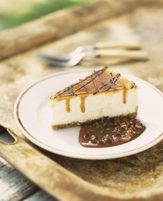 a piece of cheesecake on a plate with caramel sauce