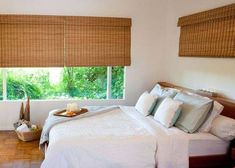 a bed sitting under a window next to a tray with food on top of it