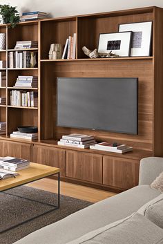 a living room filled with furniture and a flat screen tv mounted on a wooden wall