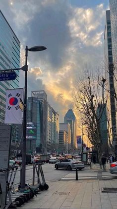 cars are parked on the street in front of tall buildings with skyscrapers behind them