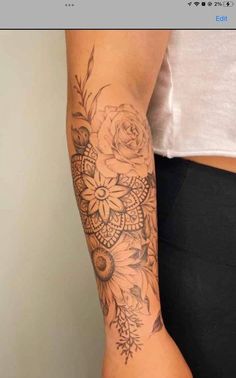 a woman's arm with flowers on it and an intricate design in the middle