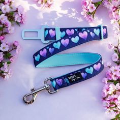 two lanyards with hearts on them sitting next to pink flowers