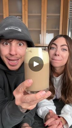 a man and woman taking a selfie with a cup of coffee in front of them