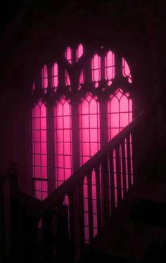 the stairs are lit up with bright purple lights in front of an arched glass window