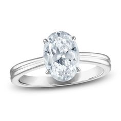 an oval cut diamond ring with two thin bands on the band, set in white gold