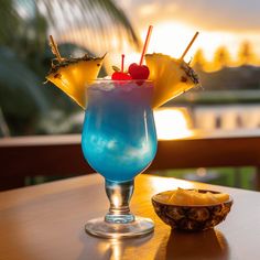 a blue and yellow drink sitting on top of a table next to a pineapple