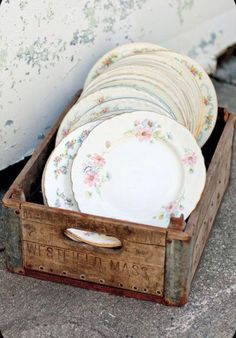 an old wooden box filled with lots of plates