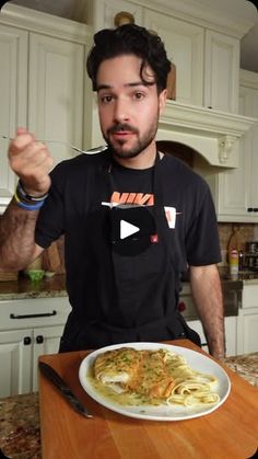 a man sitting at a kitchen table with a plate of food in front of him