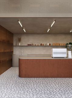 an empty counter in a kitchen with lots of shelves and lights on the wall above it