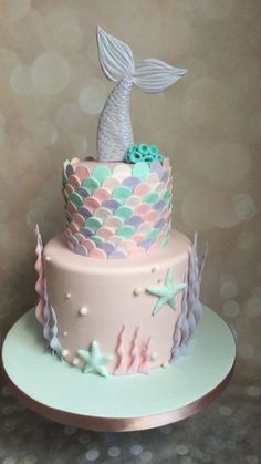 a pink and blue cake with a mermaid tail on top