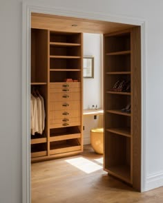 an open closet with wooden shelves and drawers