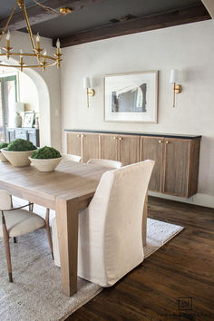 a dining room table with two bowls on top of it and chairs around the table