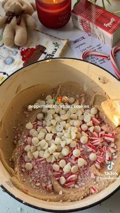 a pot filled with candy canes and marshmallows on top of a table