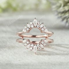 two rose gold wedding rings with pear shaped diamonds on the top, and an open diamond ring