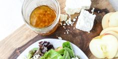 a salad with lettuce, cheese and an apple next to it