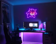 a desk with a computer on it under a neon sign