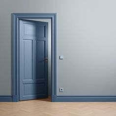 an empty room with a blue door and wooden parquet floor in front of it