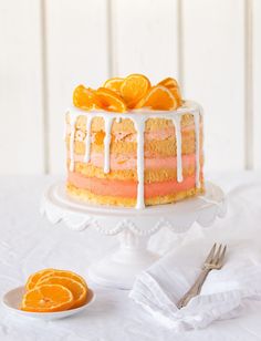 a cake with oranges on top and icing drizzled over it