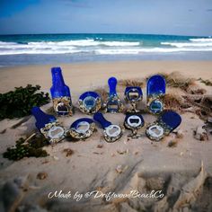 there are many blue glass bottles on the beach