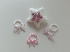 three little hair clips with pink bows and sequins on the top one has a star