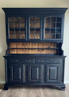 an old black china cabinet with glass doors