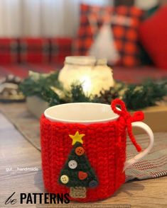 a knitted coffee cup cozying with buttons and a christmas tree